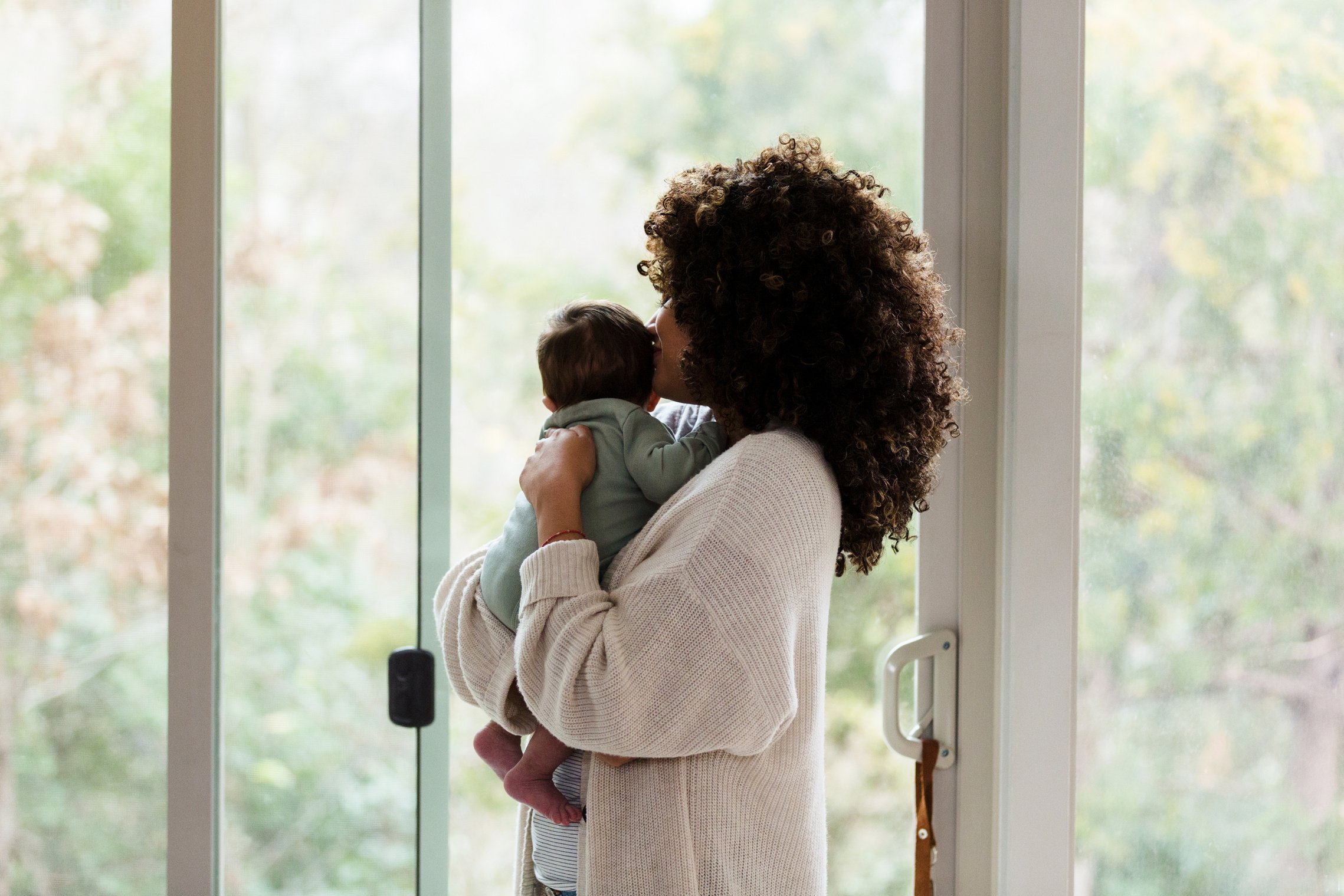 New mom and baby look out window